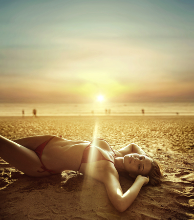 Portrait of a beautiful woman laying on a tropical beachの写真素材