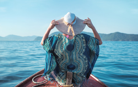 Young, relaxed woman on a small asian boat - tropical panoramaの写真素材