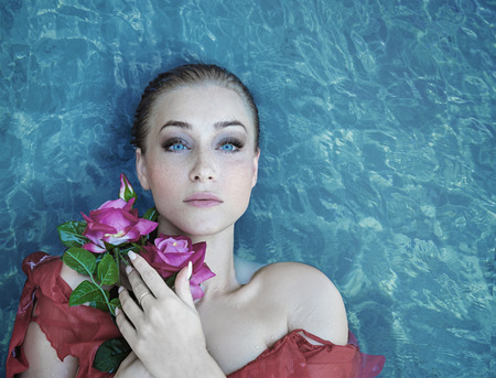 Sensual blonde lying in a clear sea waterの写真素材