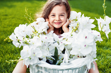 Portrait of a cute smiling girl with a flower basketの写真素材