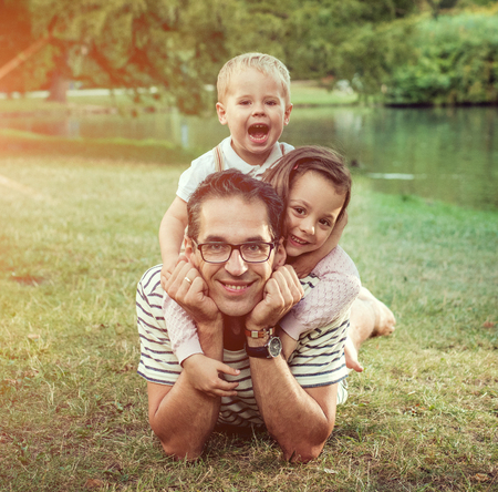 Handsome father with his beloved offsrping resting in the parkの写真素材