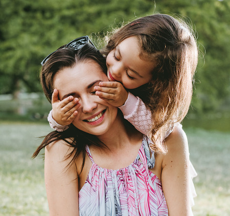 Mother and daughter having a great fun in the summer parkの写真素材