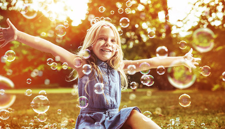 Cute little child playing soap bubblesの写真素材