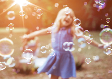 Cheerful, little girl enjoying bubble blowingの写真素材