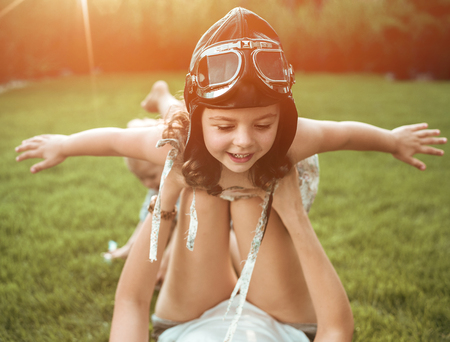 Little pilot - girl having fun with a young, relaxed momの写真素材