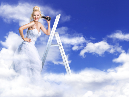 Cheerful and blond bride on heaven's stairsの写真素材