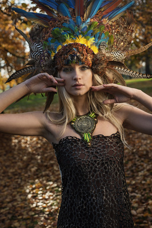 Pretty blond woman wearing coronet made of peacock's feathersの写真素材