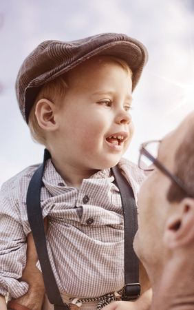 Beautiful portrait of a cute little boy hugging his fatherの写真素材