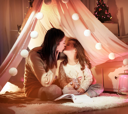 Portrait of a young mother kissing her beloved daughterの写真素材