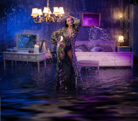 Portrait of a beautiful woman in a conceptual flooded apartmentの写真素材