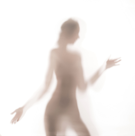 Silhouette of lady dancing behind a glass door