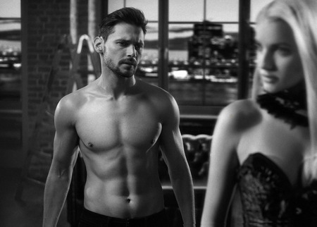 Muscular, handsome guy looking at his sexy loverの写真素材