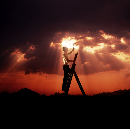 Handsome and ambitious man painting a sky - business conceptの写真素材
