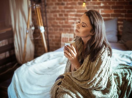 Portrait of a relaxed woman drinking coffeeの写真素材