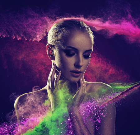 Pretty blond woman covered with colorful powderの写真素材
