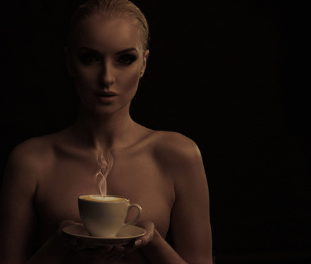 Calm blond woman holding a cup of coffeeの写真素材
