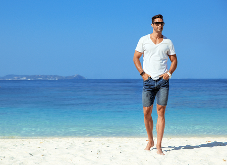 Handsome, muscular guy relaxing on a tropical beachの写真素材