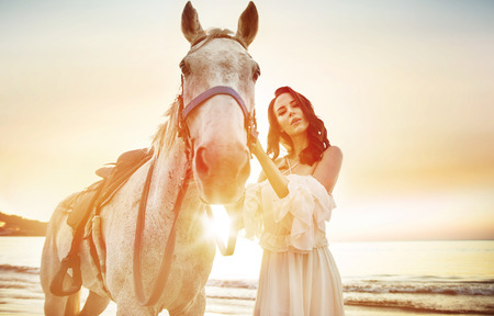 Beautiful, young woman with a calm stallionの写真素材