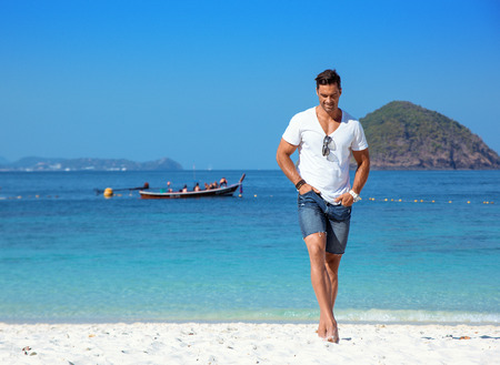 Handsome, muscular guy relaxing on a tropical beachの写真素材