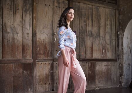 Natural brunette woman posing in front of the wooden gateの写真素材