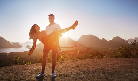 Attractive, relaxed couple posing against an island landscapeの写真素材