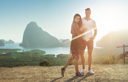 Attractive, relaxed couple posing against an island landscapeの写真素材