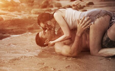 Romantic style portrait of a young couple relaxing on a beachの写真素材