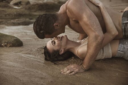 Romantic style portrait of a young couple relaxing on a beachの写真素材