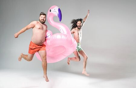 Two funny friends holding pool float birdの写真素材
