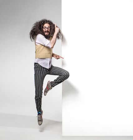 Eccentric man pointng on the white boardの写真素材