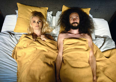 Young funny couple in a bedの写真素材