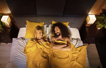 Young funny couple in a bedの写真素材