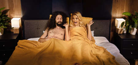 Young funny couple in a bedの写真素材
