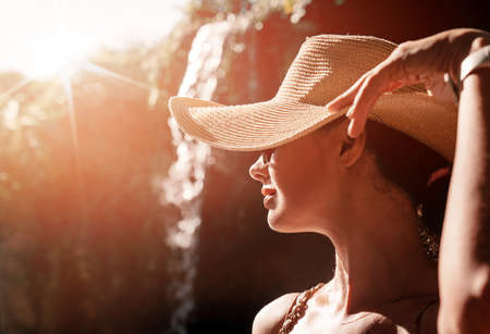 Happy young woman with straw hat enjoying her summer holidaysの写真素材