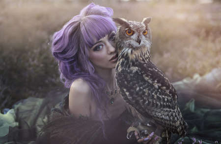 beautiful woman with owl in the natureの写真素材