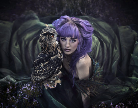 beautiful woman with owl in the natureの写真素材