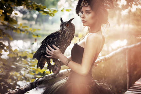 Mystical brunette beauty posing in autumn scenery