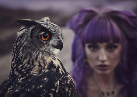 beautiful woman with owl in the natureの写真素材