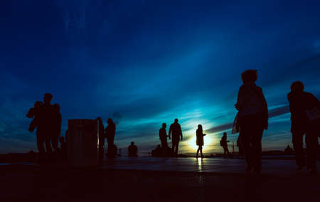 Sunset silhouettes of the people at the roofの写真素材
