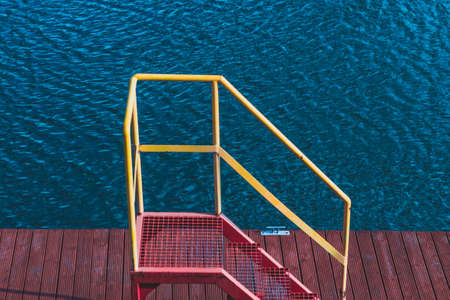 red stairs with a yellow railing leading to the pierの写真素材