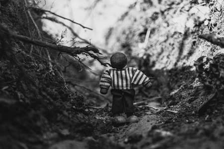 Lone wooden toy figurine with no face in natural environmentの写真素材