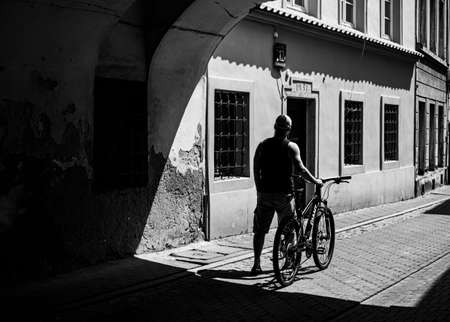 man with bicycle at the old streets of Warsaw, in monochromeの写真素材