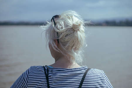 blonde girl with tied up hair seen from behindの写真素材