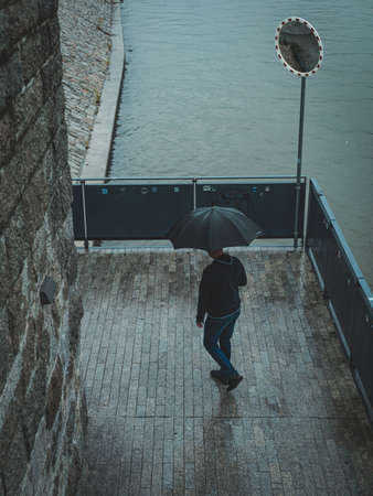 man with umbrella, view from above, city riverside boulevardsの写真素材