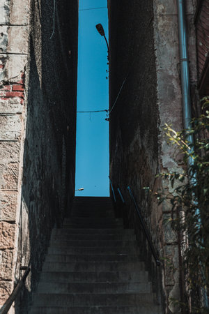 passage with stairs between buildings in small townの写真素材