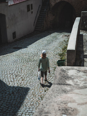 woman on cobblestone street in old townの写真素材