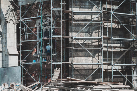 man on the scaffolding surrounding a historic buildingの写真素材