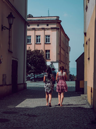 women in dresses lit by the sun, streets of old town