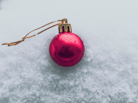 Christmas bauble in the snow, single red baubleの写真素材