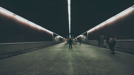 silhouettes of people in modern underground tunnel